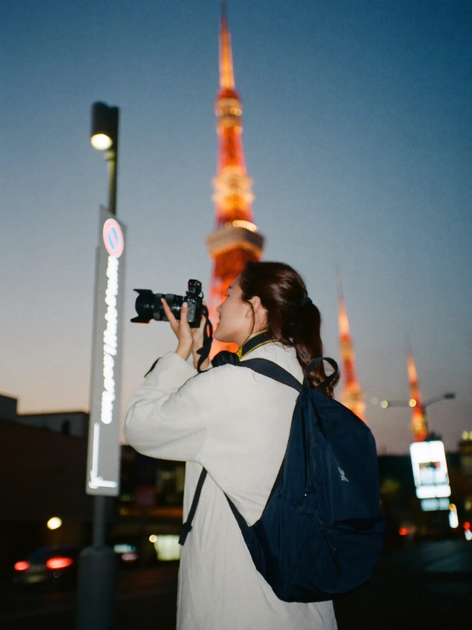A creator shooting content on a neon Tokyo street at night
